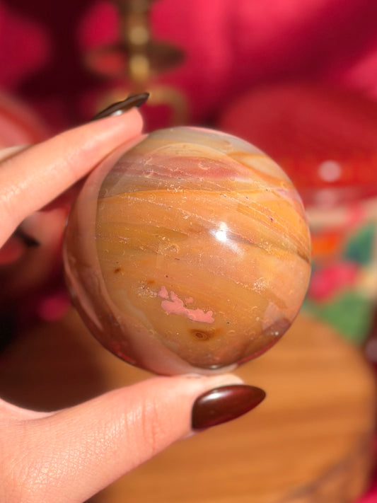 Terracotta pink zebra jasper sphere with a natural moon shaped pattern