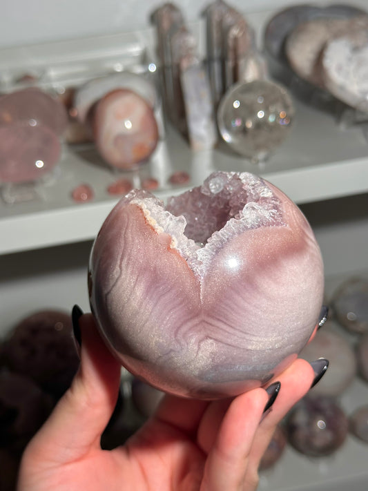 Lavender-toned glittery Brazilian pink amethyst sphere with stunning quartz cave
