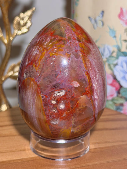Vibrant red petrified wood egg with sparkling quartz pockets