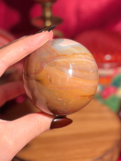 Terracotta pink zebra jasper sphere with a natural moon shaped pattern