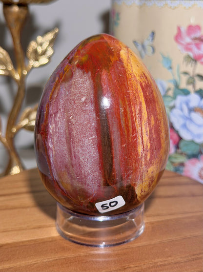 Vibrant red petrified wood egg with sparkling quartz pockets