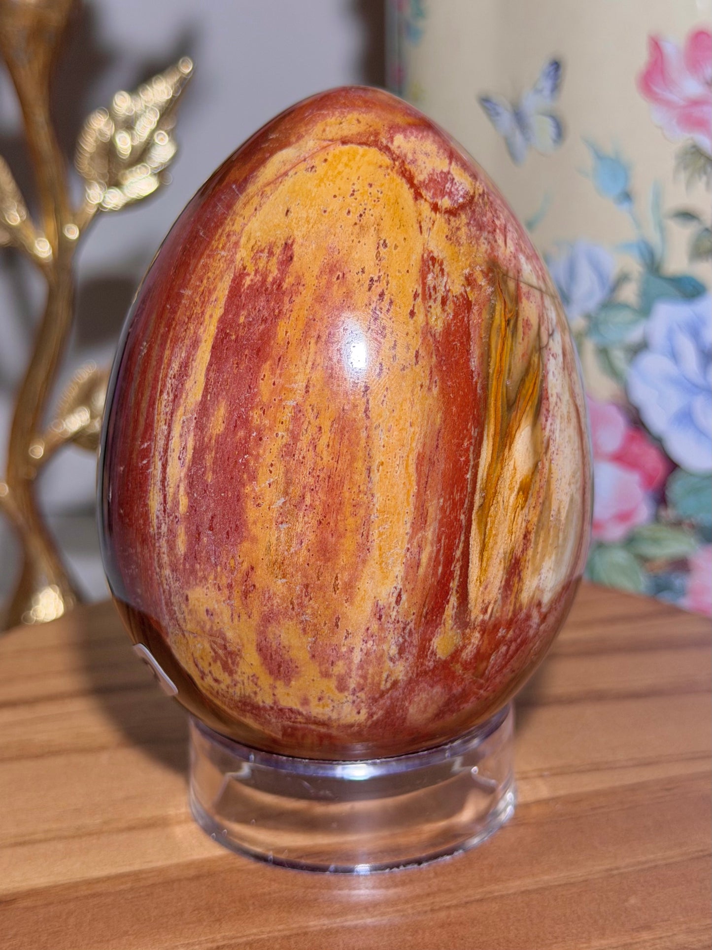 Vibrant red petrified wood egg with sparkling quartz pockets