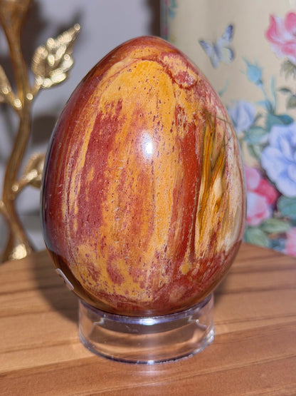 Vibrant red petrified wood egg with sparkling quartz pockets