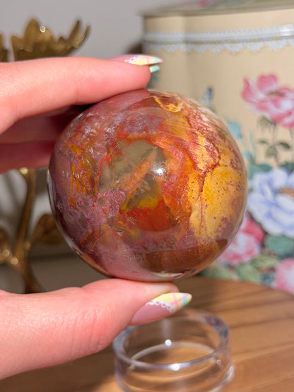 Vibrant red petrified wood egg with sparkling quartz pockets