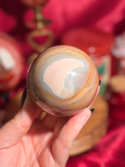 Terracotta pink zebra jasper sphere with a natural moon shaped pattern