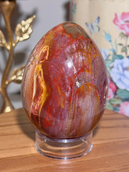 Vibrant red petrified wood egg with sparkling quartz pockets