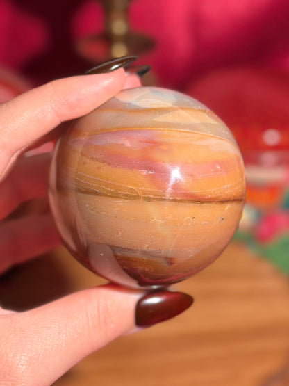 Terracotta pink zebra jasper sphere with a natural moon shaped pattern