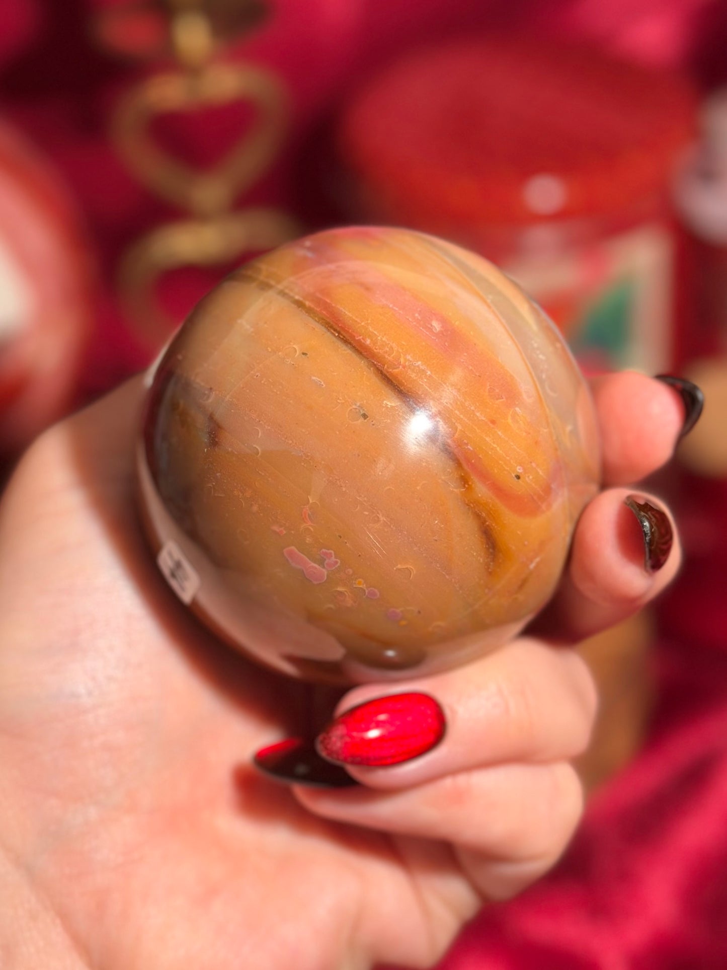 Terracotta pink zebra jasper sphere with a natural moon shaped pattern